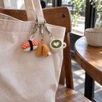 Crochet food charms clipped to a canvas bag