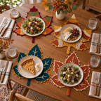 Four-place dining table with food plates resting on separate Harvest Mosaic, Amber Lace, Teal & Gold and Copper Vein crochet leaf mats.