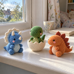 A green hatching T-rex in a cream zigzag eggshell beside a blue Triceratops and orange Stegosaurus on a windowsill.