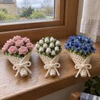 Peony, lily of the valley and cornflower crochet coaster bouquets tied with white bows on a wooden windowsill.