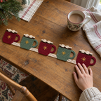 An adult hand touching a cocoa mug crochet runner on a wooden table beside a ceramic mug and linen napkin.