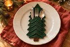 Classic Pine crochet cutlery holder with green panels and a brown trunk, holding a knife, fork and spoon on a Christmas table.