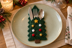 Bauble Tree crochet cutlery holder with red, gold and white baubles and a yellow front star, holding a knife, fork and spoon on a Christmas table.