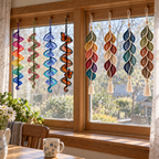Four colourful lace helix spinners and four open leaf cascades with cream tassels hang around a wooden home window.