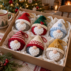 Six colourful crochet gnome baubles nestle in ivory tissue inside an open kraft gift box.