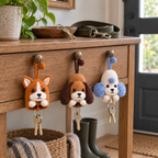 Corgi, Beagle and Poodle crochet key pouches hanging from a hallway console beside a dog lead and keys.