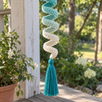 A close view of the aqua and cream crochet spiral turns and the teal tassel.