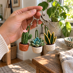 An adult hand holding keys with miniature cactus, succulent and snake plant crochet charms on yarn loops and keyrings.