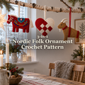 Red Dala horse, red-and-ivory woven heart and straw-coloured Yule goat crochet ornaments hanging from a birch branch in a white Christmas room with candles and greenery.