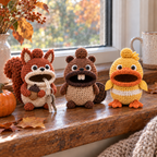 Squirrel, Beaver and Duck crochet key pouches stand on an autumn windowsill beside leaves and a small pumpkin. The Squirrel holds an acorn and has two keys outside its mouth.