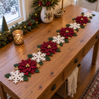Poinsettia Garden crochet table runner with layered burgundy flowers, ivory snowflakes, green leaves, red crochet berries and small gold snowflakes.