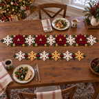 Poinsettia Garden and Snowflake Garland crochet table runners side by side on a wooden Christmas dining table, with plates and mugs beside them.
