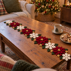 Poinsettia Garden crochet table runner with burgundy poinsettias and ivory snowflakes on a living room coffee table by a lit Christmas tree.