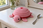 Valentine pop-up crochet turtle coaster, a pink shell with a flat red heart and matching red edge, shown with no cup, a rounded domed shell with its head and feet resting.