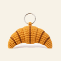 The finished crochet Croissant bag charm on its own