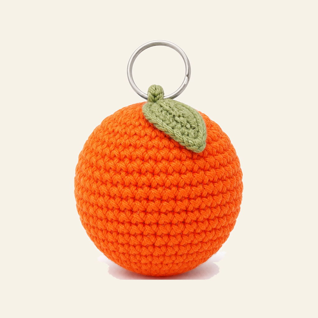 The finished crochet Orange bag charm on its own