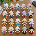 Twenty colourful curly sheep keychains with different chest motifs arranged together on a wooden table.
