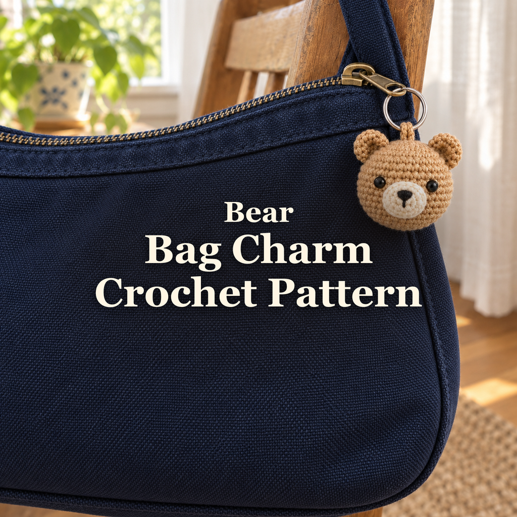 Tan crochet bear bag charm with round ears and a cream muzzle hanging from the zipper of a navy canvas bag on a wooden chair by a window. The title reads Bear, Bag Charm, Crochet Pattern.