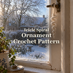 An off-white crochet icicle spiral hanging by its yarn loop in a frosty wooden window in morning light, with the title Icicle Spiral Ornament Crochet Pattern.