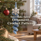 Ice-blue crochet spiral ornament with an off-white snowflake topper hanging from a Christmas tree branch beside a red bauble, with the title Snowflake Spiral Ornament Crochet Pattern.