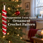 Red-and-white crocheted peppermint spiral ornament hanging from a Christmas tree branch in a cosy sitting room, with the title Peppermint Twist Spiral Ornament Crochet Pattern.