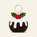 Crochet Christmas pudding ornament with a white icing cap and holly