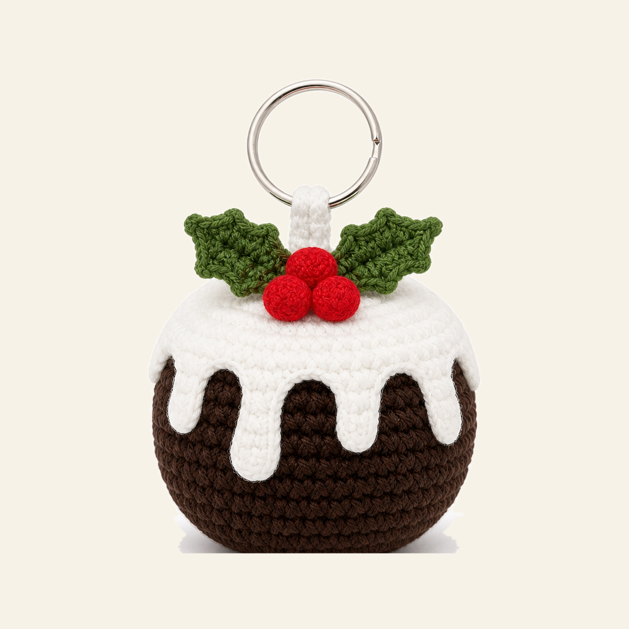 Crochet Christmas pudding ornament with a white icing cap and holly