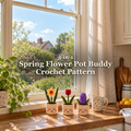 Yellow daffodil, red tulip and purple hyacinth crochet pot buddies stand together on a sunlit wooden kitchen windowsill beside a floral mug, with the pattern title above them.