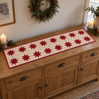 Ivory and red Nordic star crochet runner on an oak sideboard beneath a seasonal wreath.