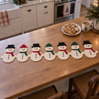 Ivory snowmen with colourful hats and scarves joined across a kitchen island beside a plate of cookies.