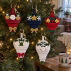 Bauble, star, bell, mistletoe and winter white crochet bouquets hanging on a Christmas tree.