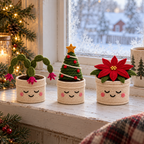 Small Christmas Cactus, Fir Tree and Poinsettia crochet plants in cream pots with smiling faces, standing on a frosty windowsill.