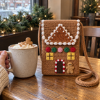 Caramel gingerbread house crochet phone bag with yellow windows, five sweets and a striped door beside a gingerbread latte on a café table.