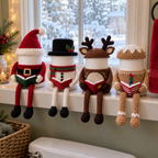 Santa, Snowman, Reindeer and Gingerbread crochet toilet roll holders reading open books in a row on a bathroom windowsill with snow outside.