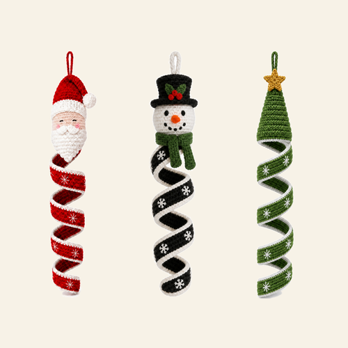 All three Christmas wind spinners in a row - a snowman in a top hat, a fir tree under a gold star and a bearded santa, each on its own crocheted corkscrew